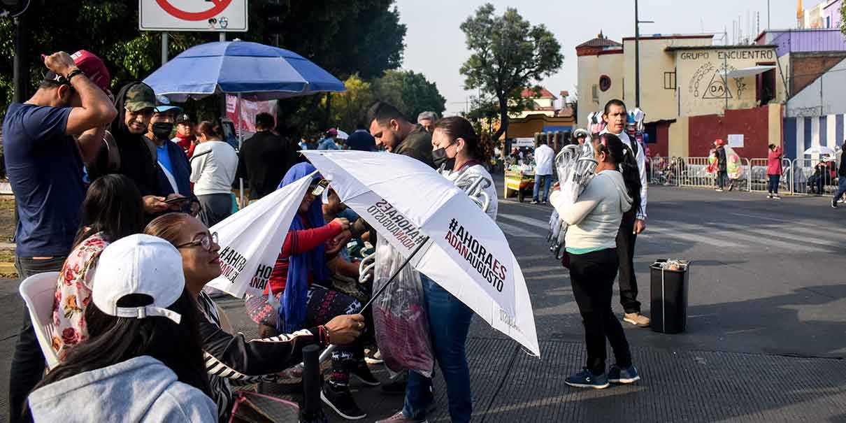 Durante el desfile aparecen las sombrillas y gorras para promocionar a corcholatas