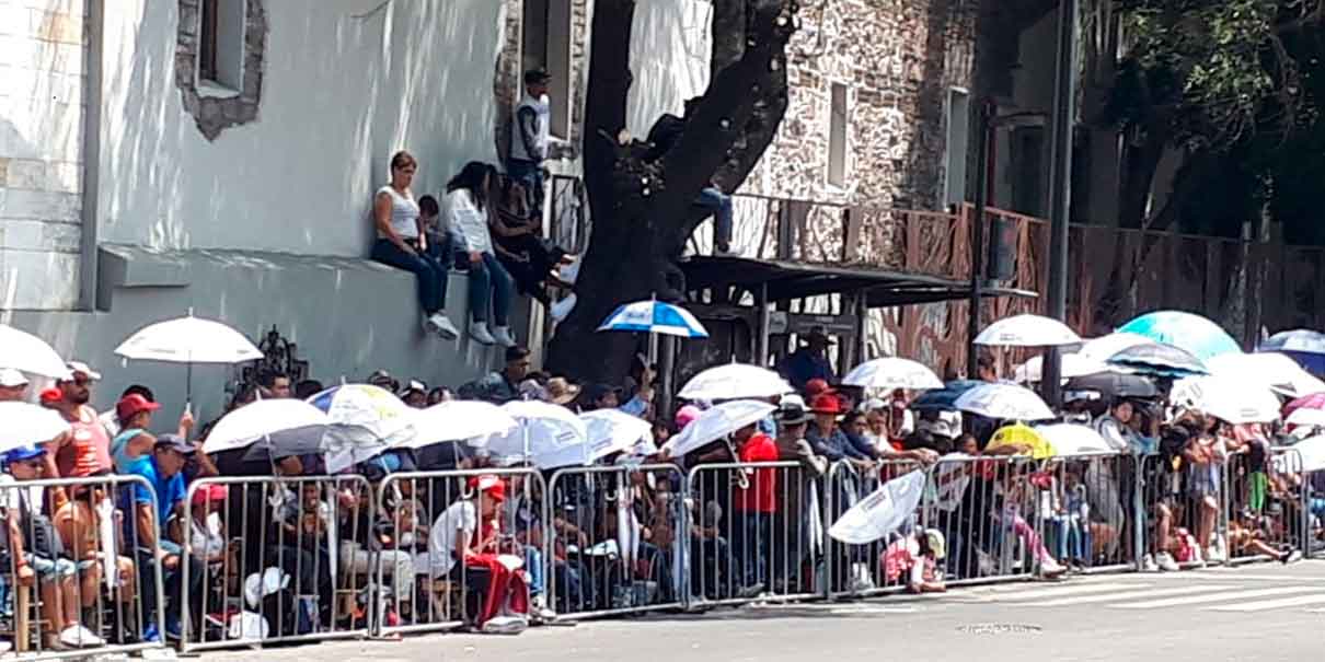 Durante el desfile aparecen las sombrillas y gorras para promocionar a corcholatas