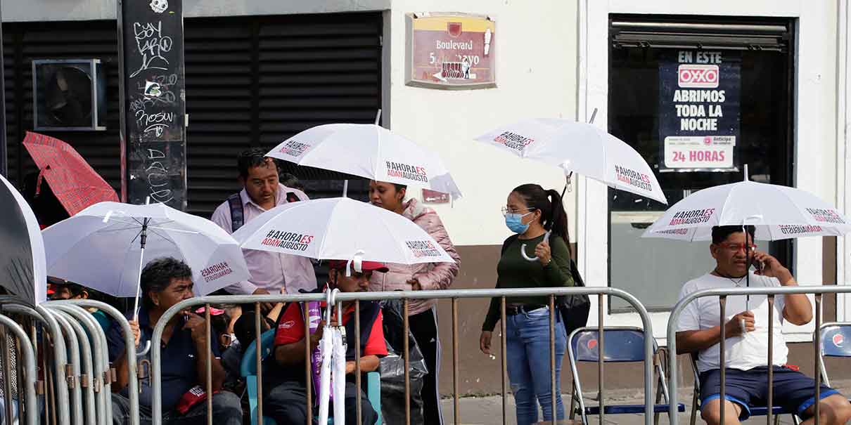 Durante el desfile aparecen las sombrillas y gorras para promocionar a corcholatas